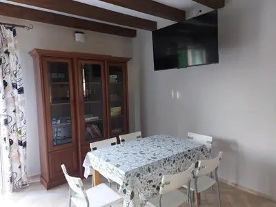 a dining room with a table and chairs and a television at WhyDeer in Wola Radziszowska