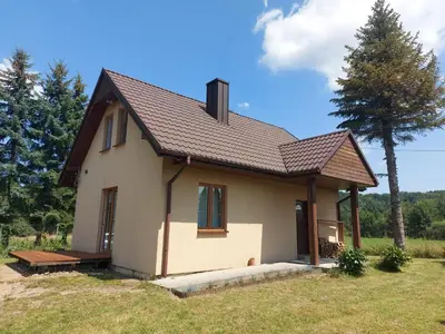 a small white house with a roof at WhyDeer in Wola Radziszowska