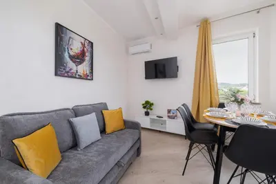 a living room with a gray couch and a table at Apartament Rodzinny z 2 Sypialniami & Klimatyzacja by Noclegi Renters in Kraków