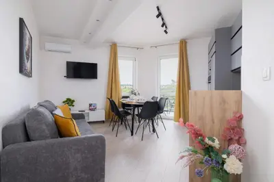 a living room with a couch and a table at Apartament Rodzinny z 2 Sypialniami & Klimatyzacja by Noclegi Renters in Kraków