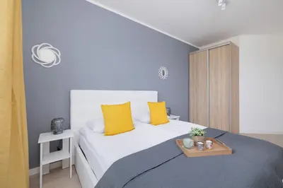 a bedroom with a bed with yellow pillows and a tray on it at Apartament Rodzinny z 2 Sypialniami & Klimatyzacja by Noclegi Renters in Kraków