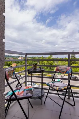 two chairs on a balcony with a view of a highway at Apartament Rodzinny z 2 Sypialniami & Klimatyzacja by Noclegi Renters in Kraków