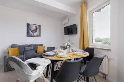 a living room with a table and chairs and a couch at Apartament Rodzinny z 2 Sypialniami & Klimatyzacja by Noclegi Renters in Kraków