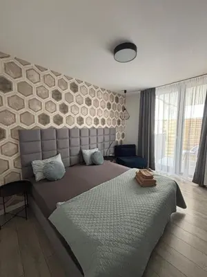 a bedroom with a large bed with a stone wall at Wow! Paradise Aparthotel in Kraków