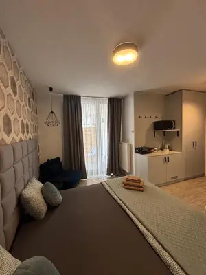 a bedroom with a large bed and a kitchen at Wow! Paradise Aparthotel in Kraków