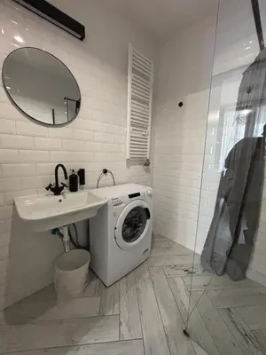 a bathroom with a washing machine under a sink at Wow! Paradise Aparthotel in Kraków