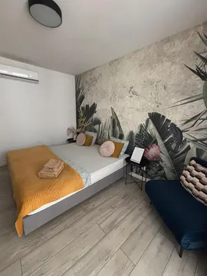 a bedroom with a bed and a wall with plants at Wow! Paradise Aparthotel in Kraków