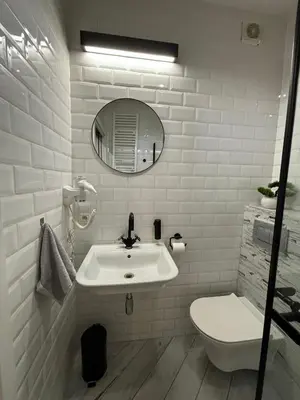 a white bathroom with a sink and a toilet at Wow! Paradise Aparthotel in Kraków