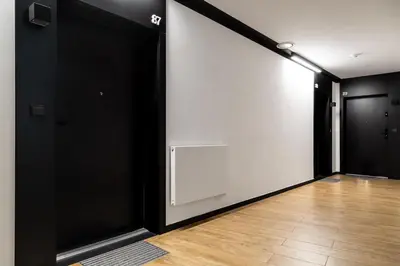 an empty room with black doors and a wooden floor at Househost Apt - Rakowicka 20H in Kraków