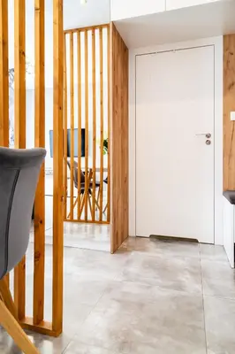 a living room with a door and a chair at Househost Apt - Rakowicka 20H in Kraków
