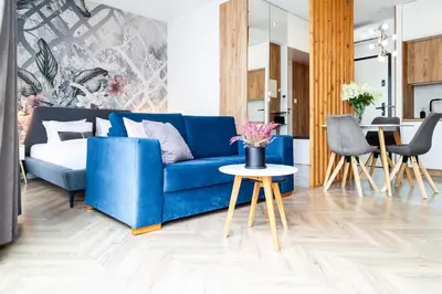 a living room with a blue couch and a table at Househost Apt - Rakowicka 20H in Kraków