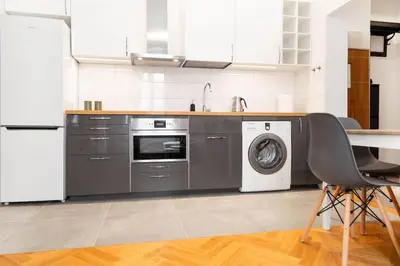 a kitchen with a washing machine and a sink at Househost Apt - Krowoderska 55 in Kraków