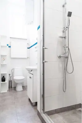 a white bathroom with a shower and a toilet at Househost Apt - Krowoderska 55 in Kraków