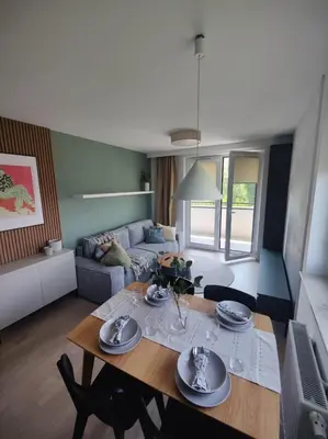 a living room with a table and a couch at New Apartment Macedońska in Kraków