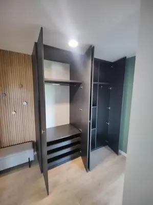 a walk in closet with black shelving at New Apartment Macedońska in Kraków