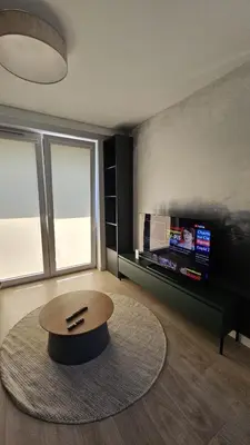 a living room with a coffee table and a tv at New Apartment Macedońska in Kraków
