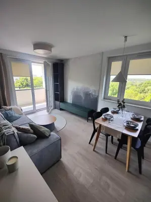 a living room with a couch and a table at New Apartment Macedońska in Kraków