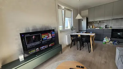 a kitchen and living room with a large flat screen tv at New Apartment Macedońska in Kraków