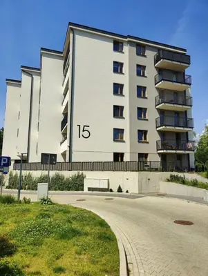 a building with a clock on the side of it at New Apartment Macedońska in Kraków