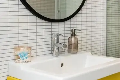 a bathroom sink with a soap dispenser on it at Heart of Cracow - AC - Retoryka 24 in Kraków