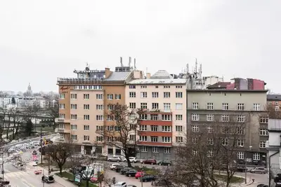 a large building with cars parked in a parking lot at Heart of Cracow - AC - Retoryka 24 in Kraków