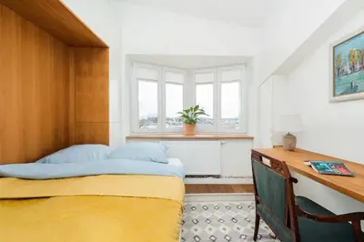a bedroom with a bed and a desk and a window at Heart of Cracow - AC - Retoryka 24 in Kraków