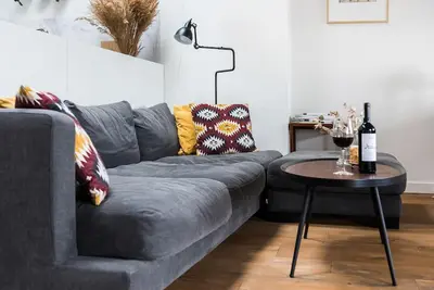 a living room with a gray couch and a table at Penthouse - Heart of Cracow - Balcony - AC in Kraków