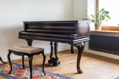 a black piano with a stool next to a window at Penthouse - Heart of Cracow - Balcony - AC in Kraków