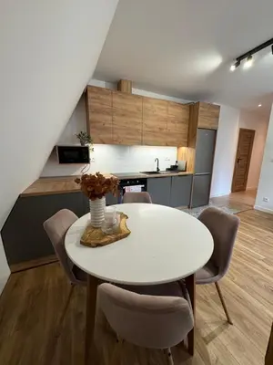 a kitchen and dining room with a white table and chairs at Apartament 2 Willa Bellevue in Rabka-Zdroj