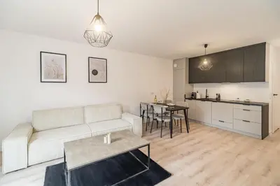 a living room with a couch and a table at Grzegórzki Apt - Balcony, AC, Shops&Tram nearby - by Rentujemy in Kraków