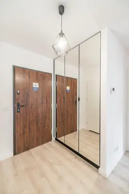 an empty room with sliding glass doors and wood at Grzegórzki Apt - Balcony, AC, Shops&Tram nearby - by Rentujemy in Kraków