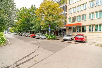 a street with cars parked in front of a building at Grzegórzki Apt - Balcony, AC, Shops&Tram nearby - by Rentujemy in Kraków
