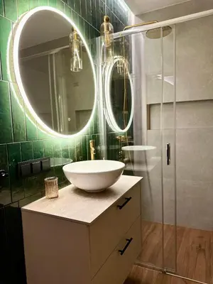 a bathroom with a sink and a mirror at Apartament Widna 3 in Kraków