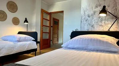 a bedroom with two beds and a mirror at Apartament Widna 3 in Kraków