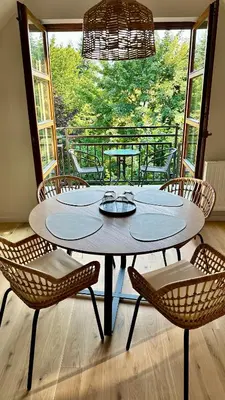 a table and chairs in a room with a balcony at Apartament Widna 3 in Kraków