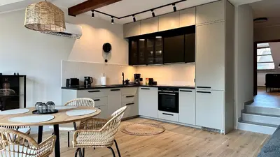 a kitchen with a table and a table and chairs at Apartament Widna 3 in Kraków
