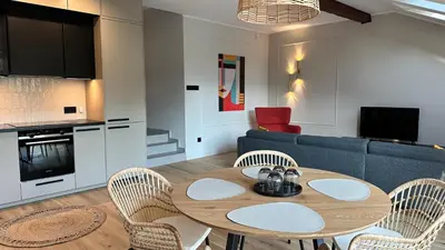 a living room with a table and chairs and a couch at Apartament Widna 3 in Kraków
