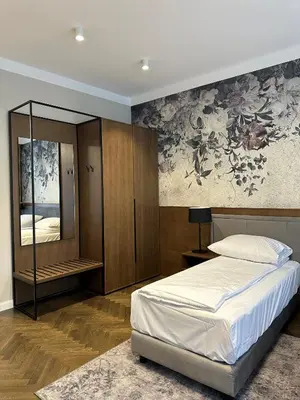 a bedroom with a bed and a painting on the wall at Dom Gościnny Uniwersytetu Jagiellońskiego in Kraków