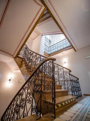 a spiral staircase in a house with a window at Dom Gościnny Uniwersytetu Jagiellońskiego in Kraków