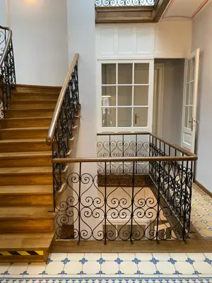 a staircase in a house with a wrought iron railing at Dom Gościnny Uniwersytetu Jagiellońskiego in Kraków