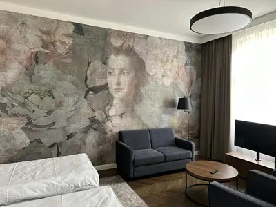 a living room with a painting of a woman at Dom Gościnny Uniwersytetu Jagiellońskiego in Kraków