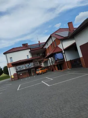 a car parked in a parking lot next to buildings at Karpiówka noclegi in Osiek