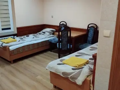 a room with two beds and a table and a desk at Karpiówka noclegi in Osiek