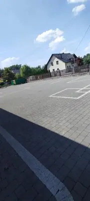 an empty parking lot with a building in the background at Karpiówka noclegi in Osiek