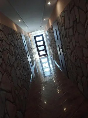 a hallway with a window and a stone wall at Karpiówka noclegi in Osiek
