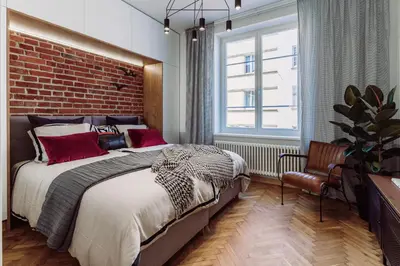 a bedroom with a large bed and a brick wall at Rzeszowska 5 Apt 7 Stylowy pobyt in Kraków