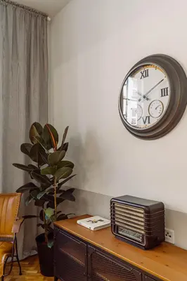 a clock on a wall above a table with a radio at Rzeszowska 5 Apt 7 Stylowy pobyt in Kraków
