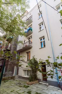 a building with a person sitting on a balcony at Rzeszowska 5 Apt 7 Stylowy pobyt in Kraków