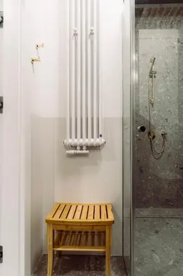 a bathroom with a shower and a wooden bench at Rzeszowska 5 Apt 12 Stylowy pobyt in Kraków