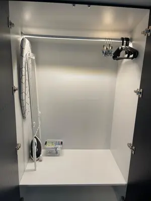 a white closet with a hair dryer on a shelf at Sunflower Apartment Kalwaryjska Street in Kraków